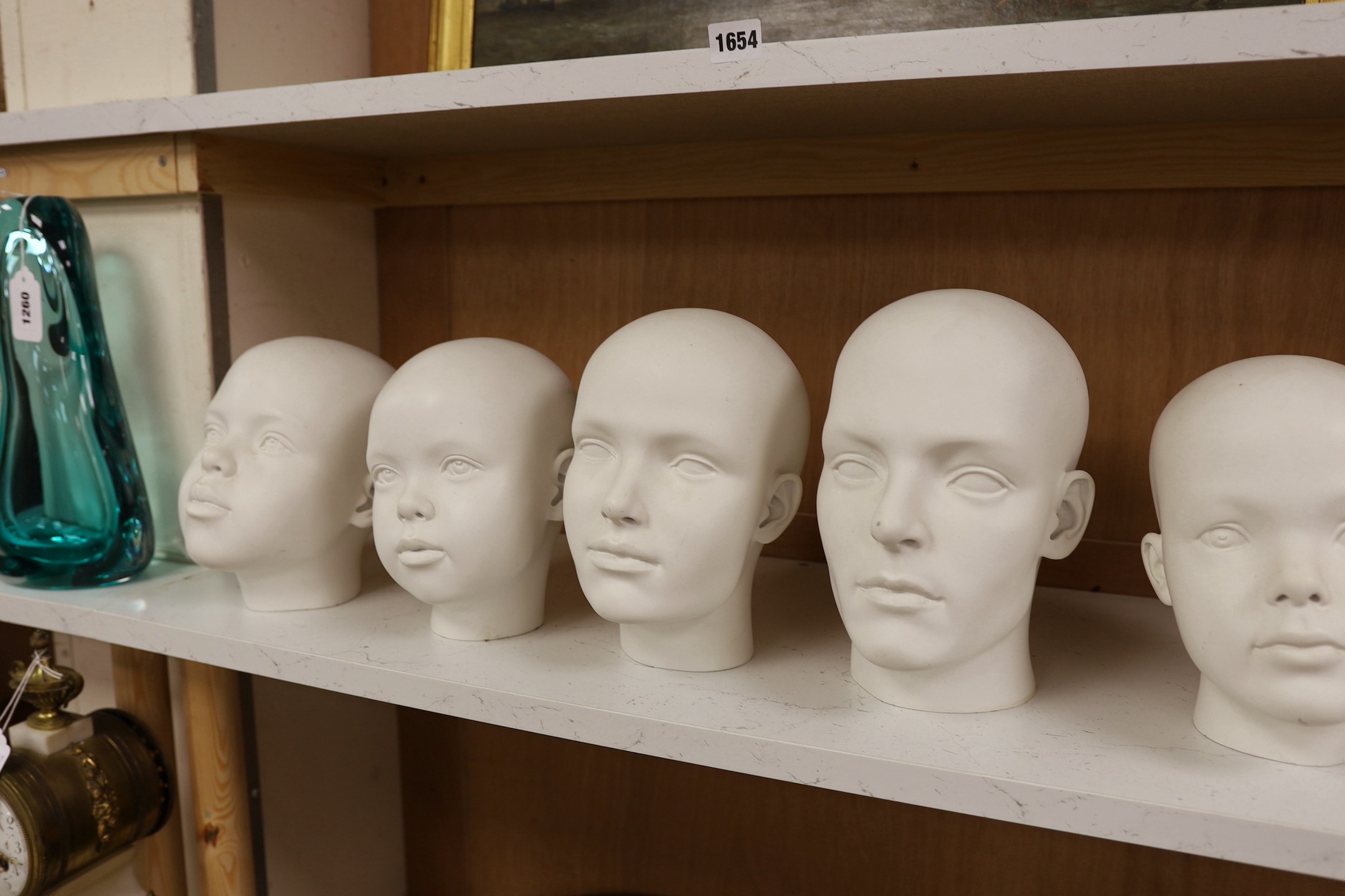 A set of seven fibreglass mannequin heads, largest 23cms high